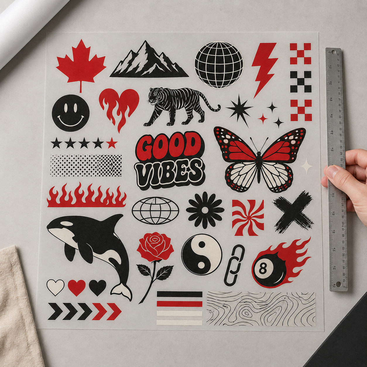 Top-down view of a 22-inch DTF gang sheet packed with varied apparel design elements in red, black, and cream